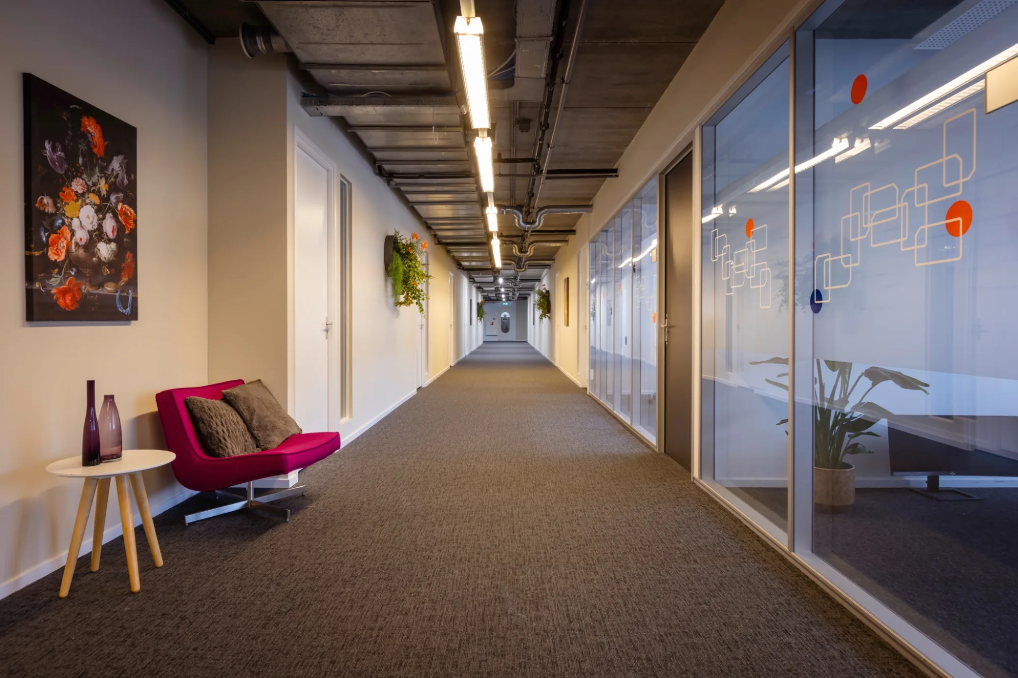 Vergaderzaal met U-vormige tafelsetting, zwarte mesh stoelen, flatscreen en industrieel betonnen plafond