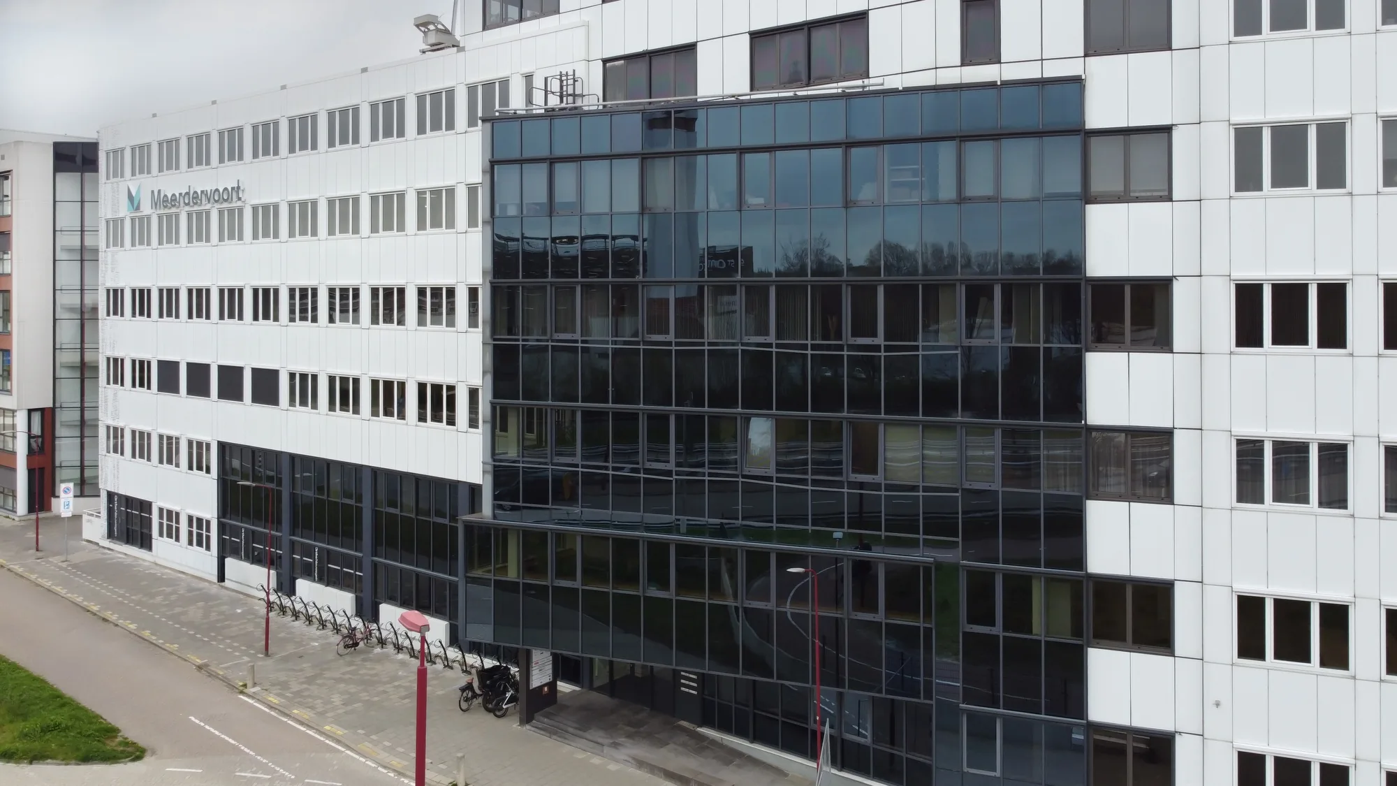 Luchtfoto van het kantoorcomplex in Nieuwegein met wit-blauwe gevel en het Meerdervoort-logo op de zijgevel