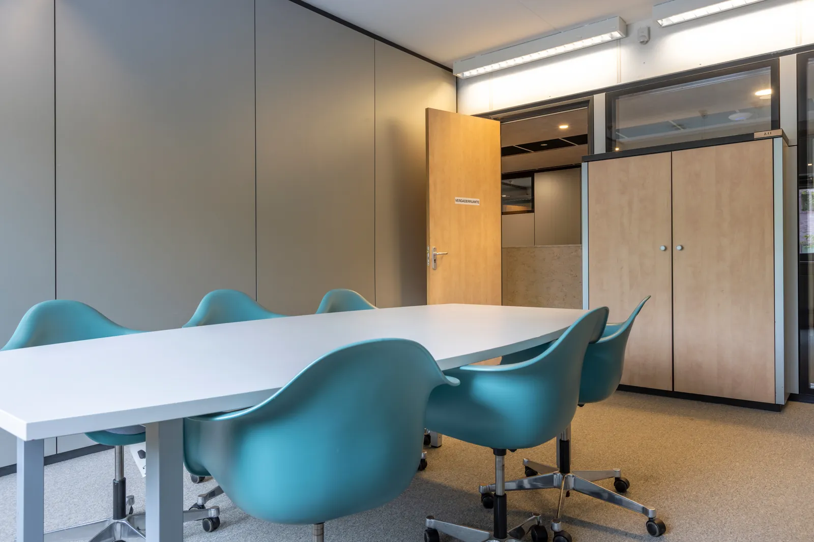 Vergaderruimte in Delft ingericht met turquoise designstoelen en ruime werkbladen