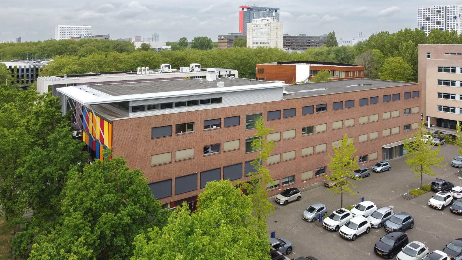 Luchtfoto FlexOffiZ Delft met kleurrijke gevel en de TU Delft skyline op de achtergrond