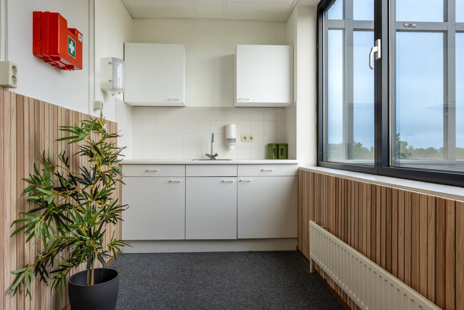 Lichte kantoorunit te huur bij FlexOffiZ Zwijndrecht met groot raam en uitzicht op groen