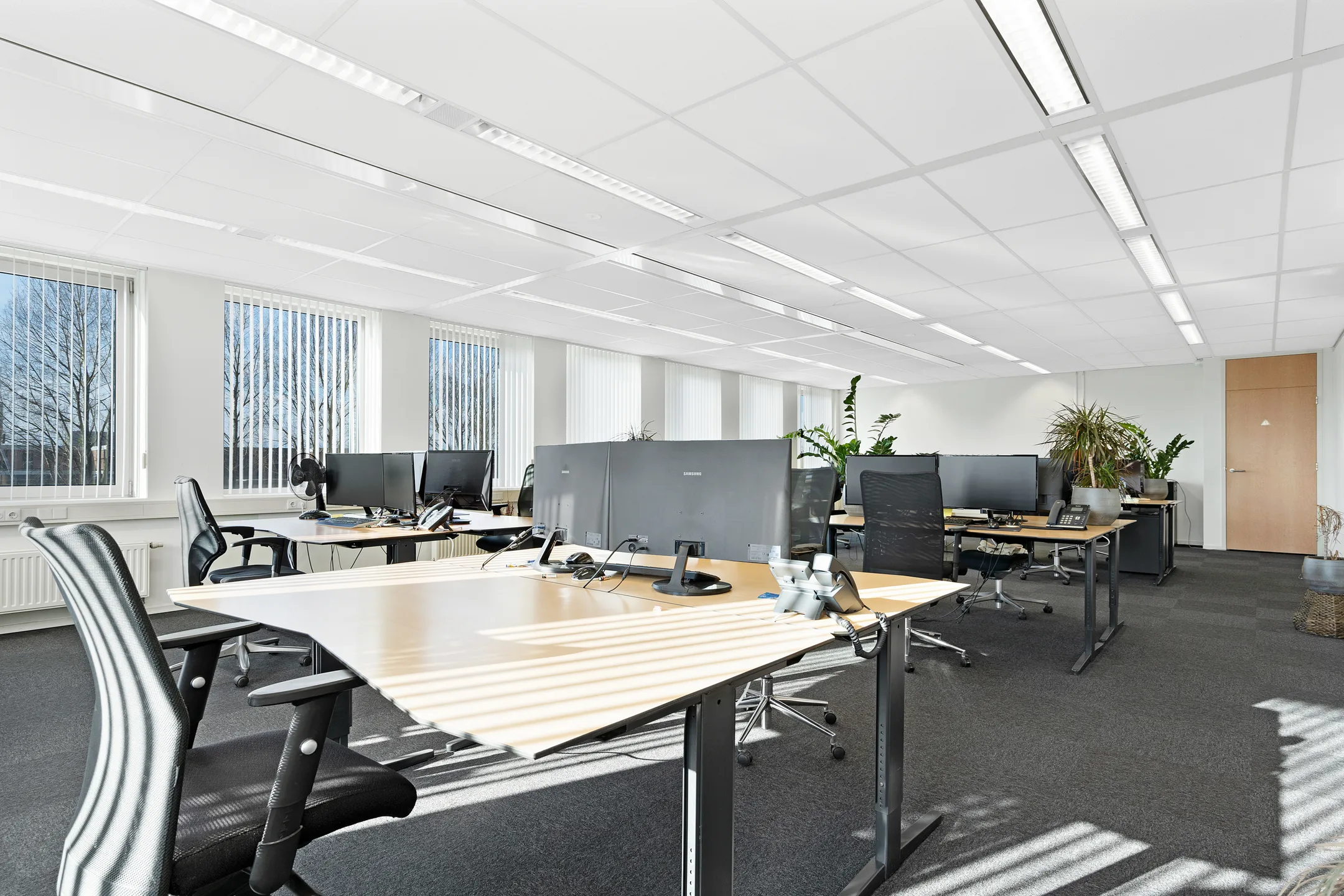 Open kantoorruimte met werkplekken en veel daglicht